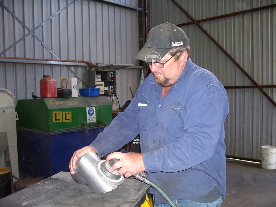 Heath Rowe in his workshop working on a part for his harvester heat shield. Photo: supplied