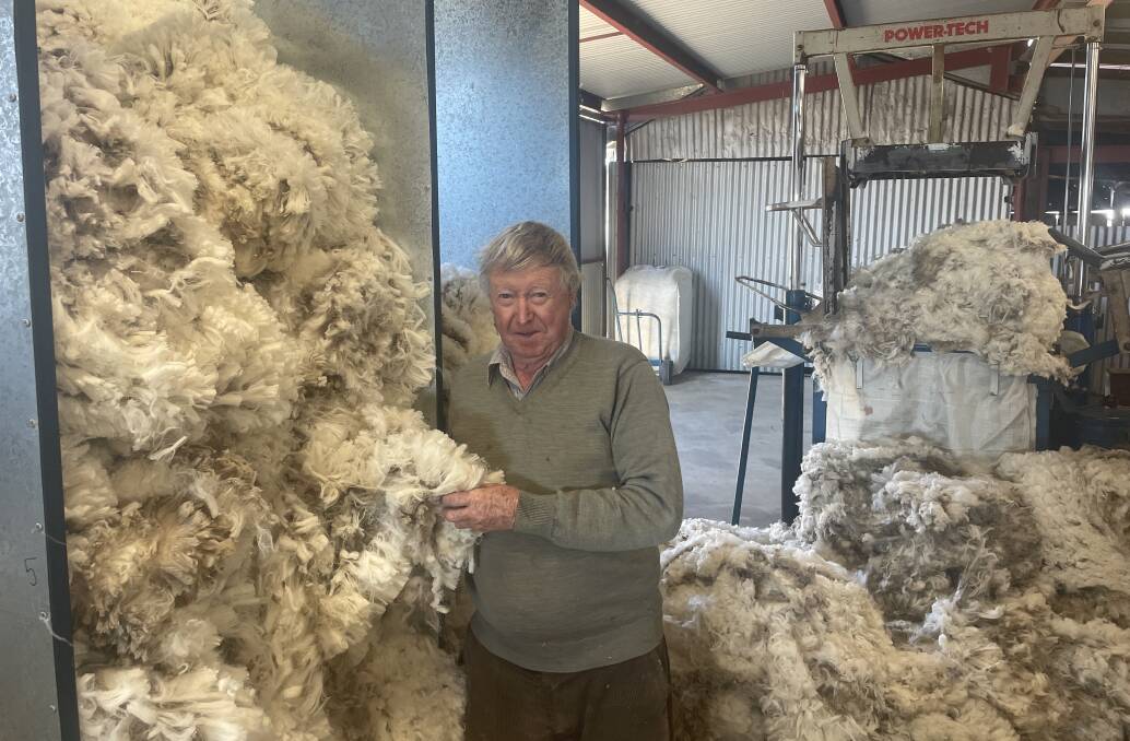 Alan Ticehurst proudly admiring one of the superfine fleeces grown on the family property near Bookham.