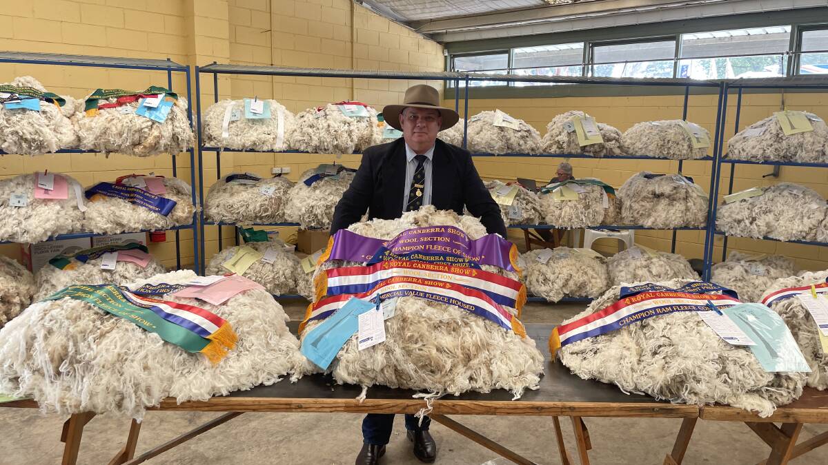 Stuart Sutherland, chief steward wool section at the 2024 Royal Canberra Show with the grand champion fleece exhibited by the Lette family, Conrayn, Berridale.