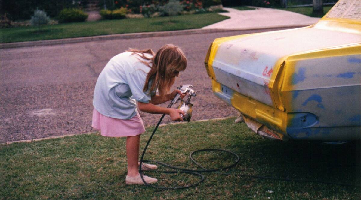 Jodie Lanyon helps spray her father Peter's original Kidney Kar Rally vehicle. Picture supplied