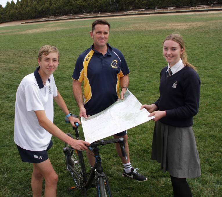 The Armidale School coordinator Challenge and Service, Jim Pennington, shows the route of the trek to Year 10 students Toby Hall and Isabella Gooch.