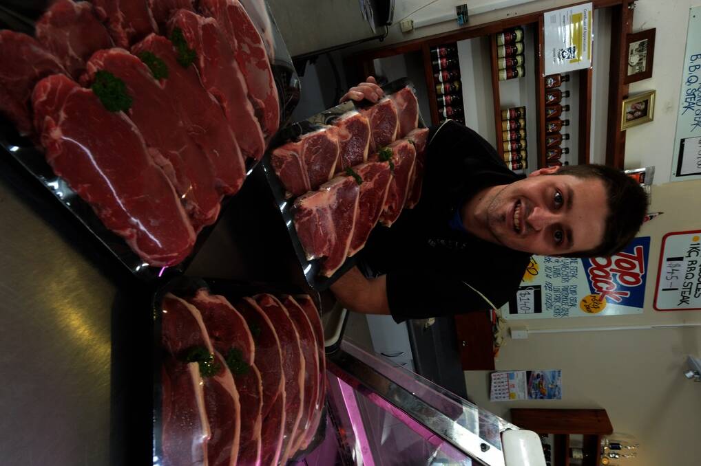 Third generation Butcher Zak Needs in his family Bermagui Fresh Food Emporium shop with Simmental Meat cuts.